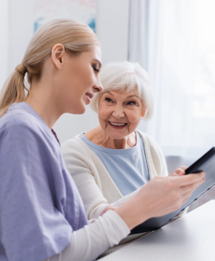 A woman and an older person looking at something on a tablet.