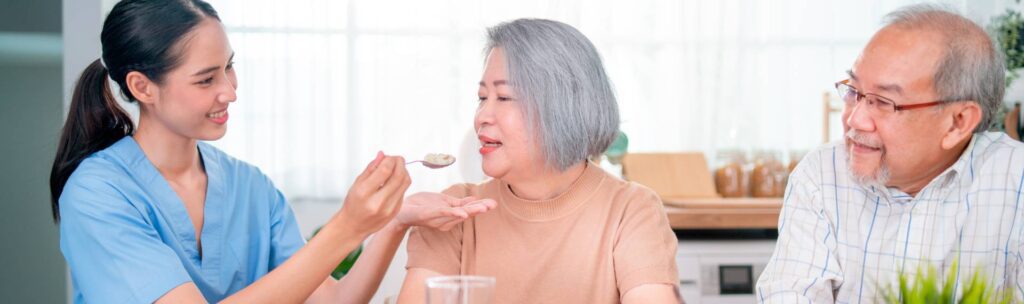 A woman is eating something from a spoon.